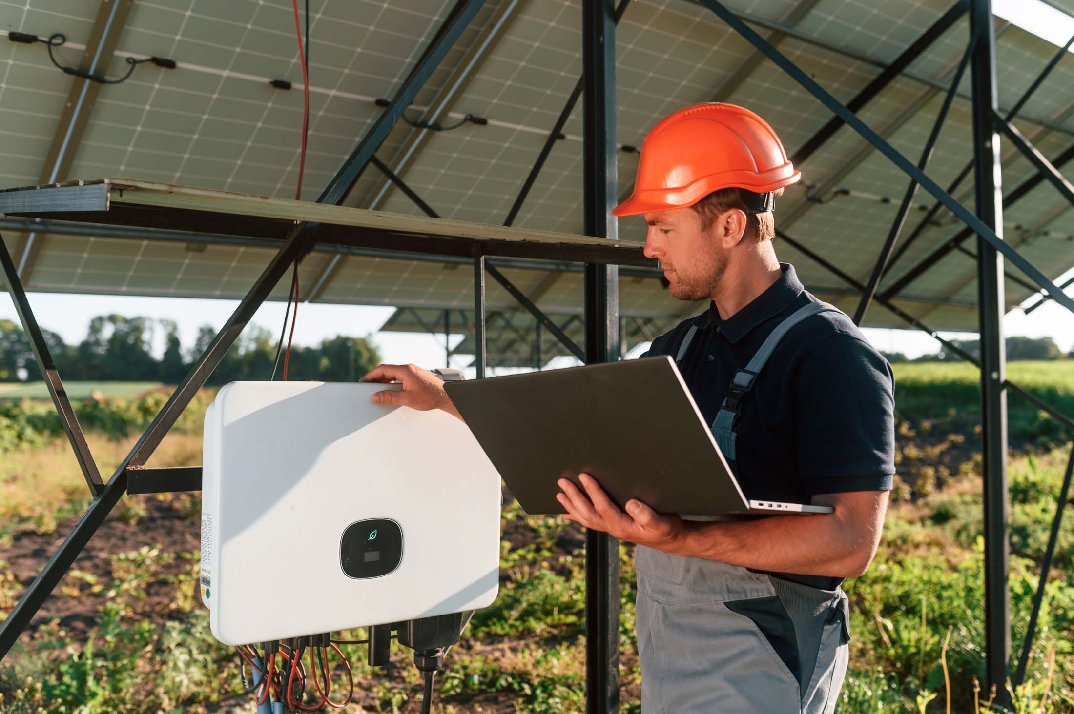 Standing and holding laptop. Man is doing operating and maintenance in solar power plant
